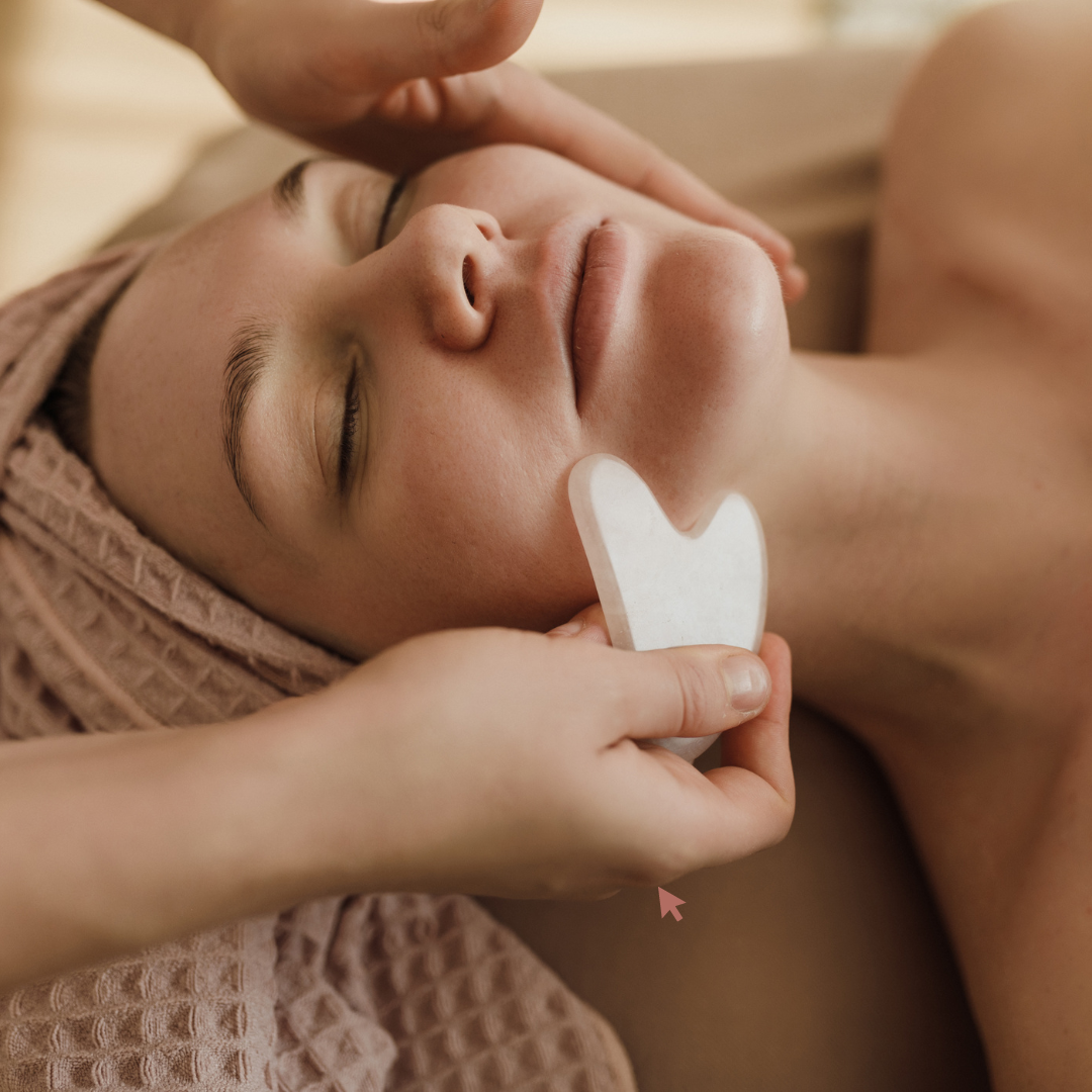 A woman receiving a spa treatment with Gaia gua sha facial massage tool