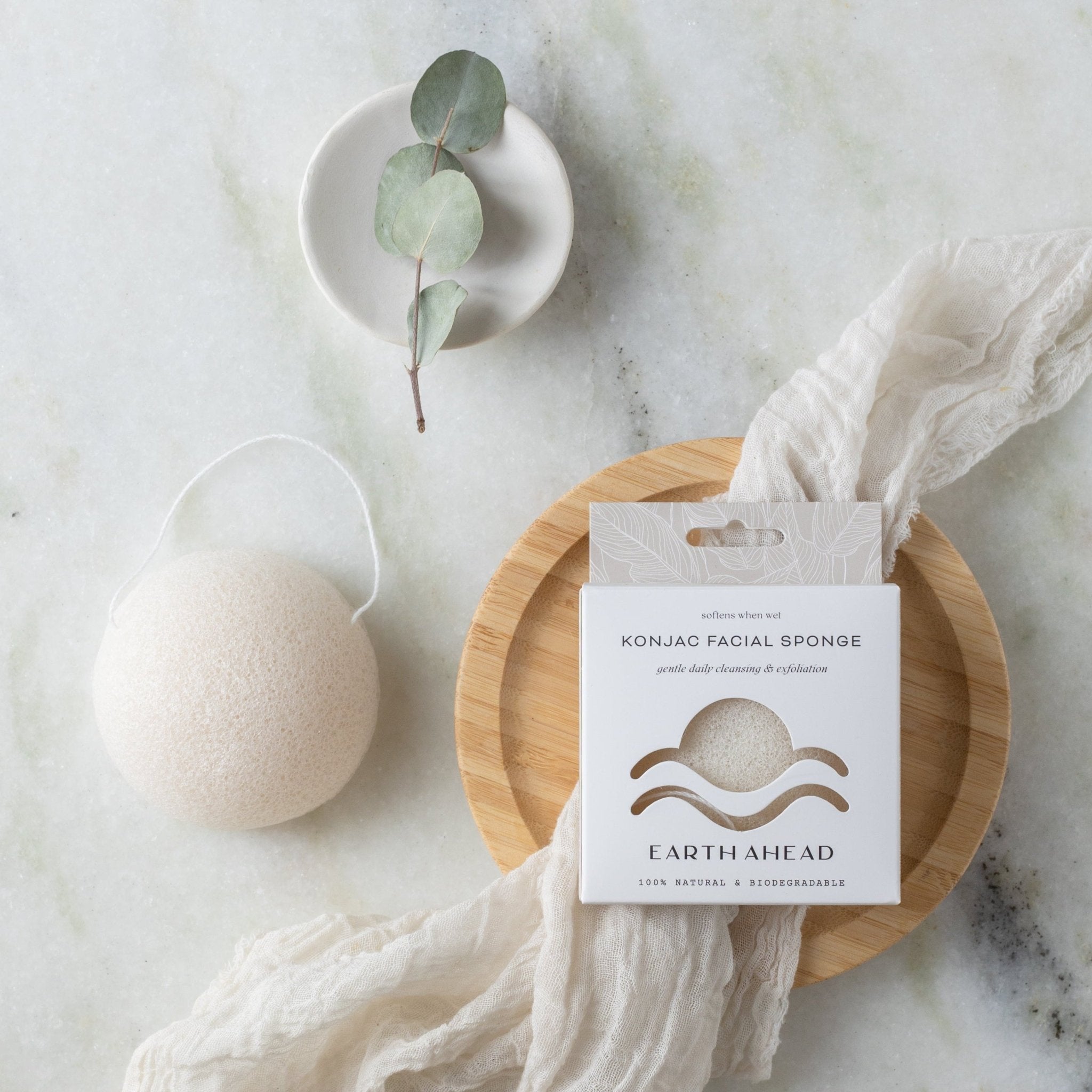 Natural white konjac facial sponge beside its box