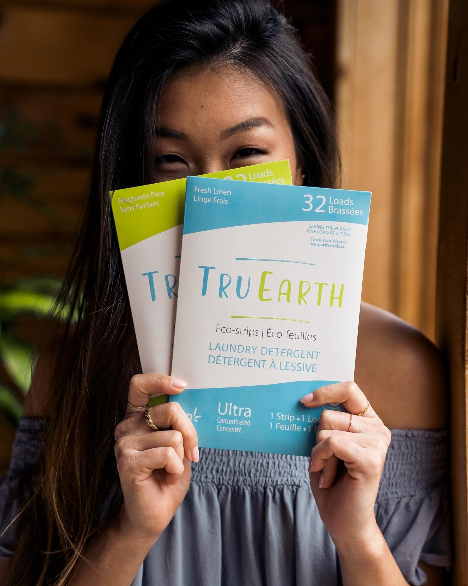 A woman holding 2 packs of TruEarth Laundry Detergent Strips - Fresh Linen and Unscented - Earth Ahead